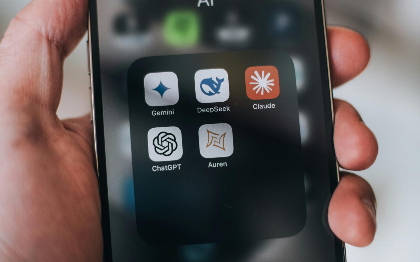 Hand holding a phone with ai application icons. by Aerps.com courtesy of Unsplash.