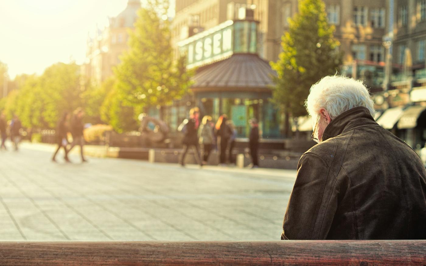 man sitting on brown wooden bench by Huy Phan courtesy of Unsplash.