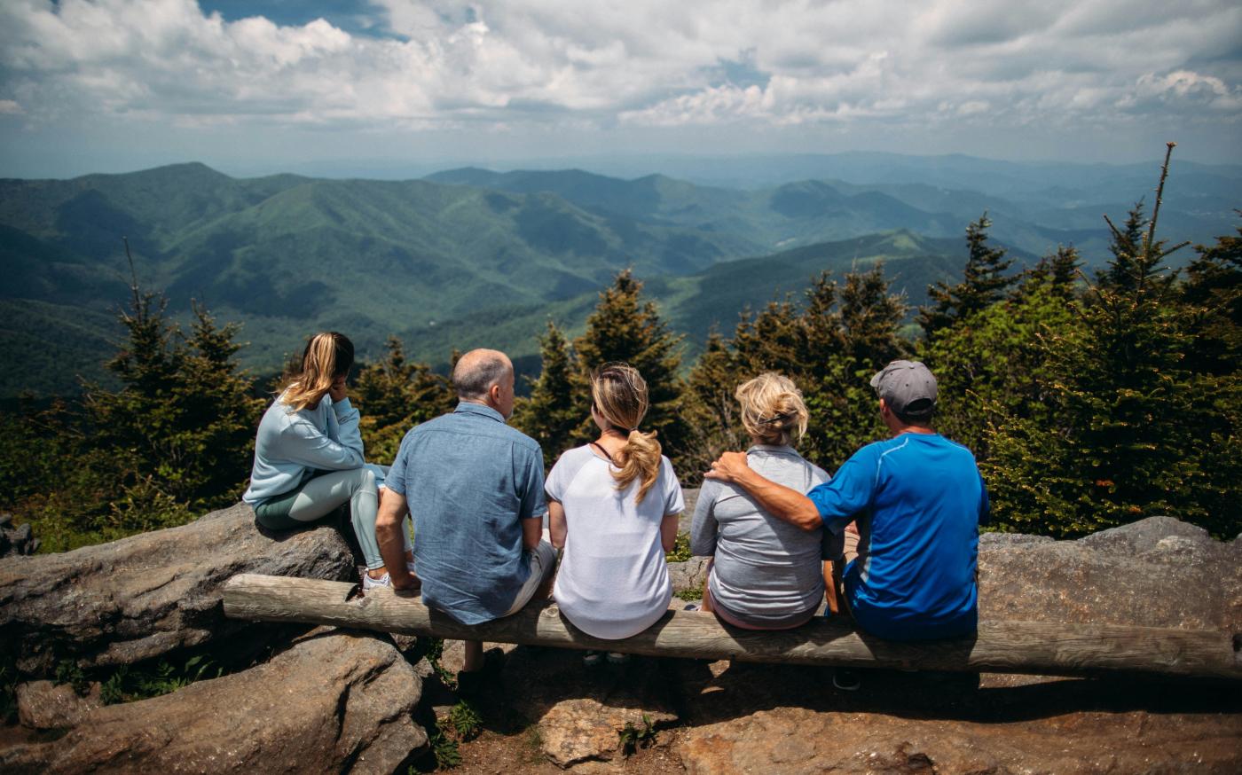 group of people sitting on rocks overlooking mountain by Roberto Nickson courtesy of Unsplash.