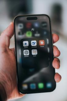 Hand holding a phone with ai application icons. by Aerps.com courtesy of Unsplash.