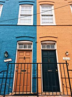 a blue building with a black door by Meg Jenson courtesy of Unsplash.