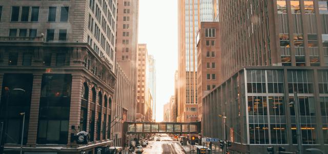 cars on road in between high rise buildings during daytime by Josh Hild courtesy of Unsplash.