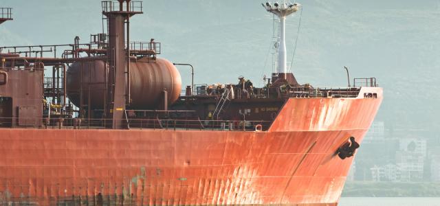 Large red cargo ship sails on the water by Adem Percem courtesy of Unsplash.