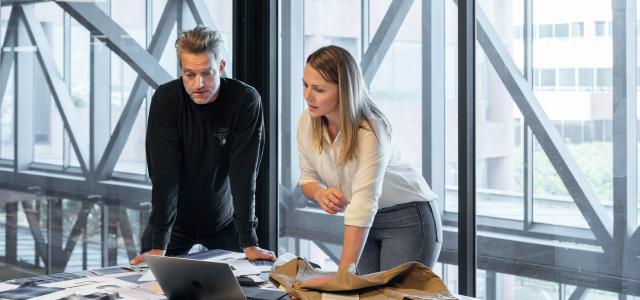 man and woman sitting at table by LinkedIn Sales Solutions courtesy of Unsplash.